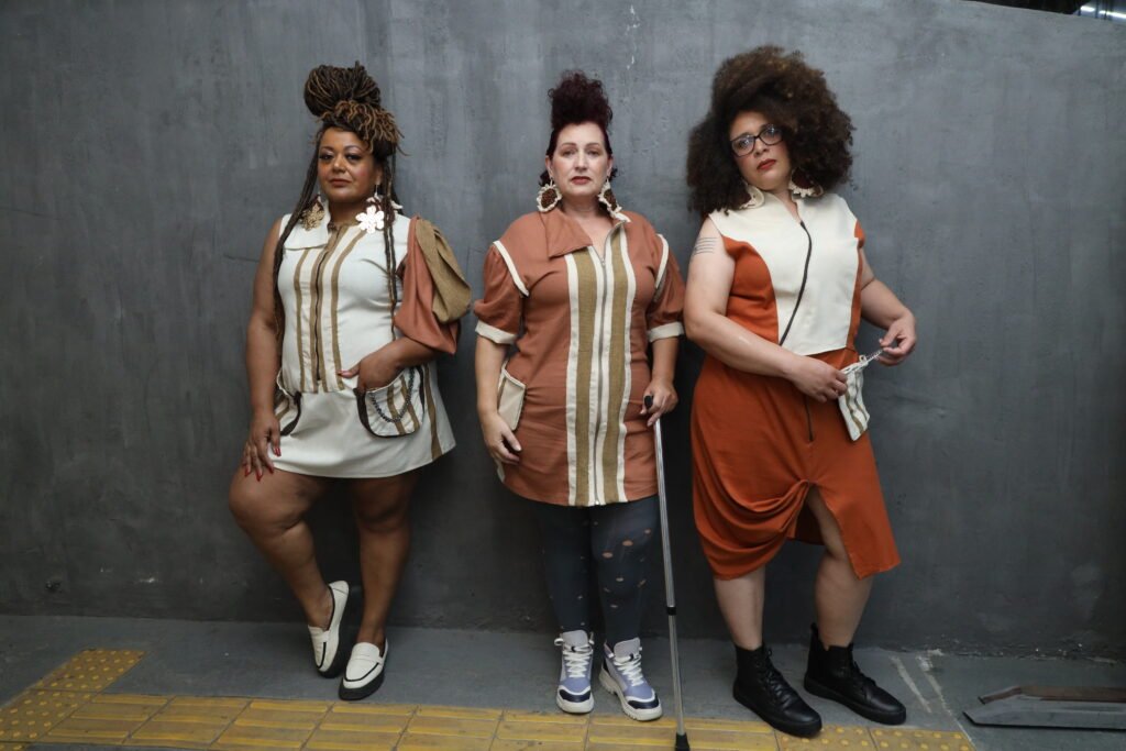 Legenda da Foto:  das três modelos posando com as peças da coleção Vênus Sara em pé.